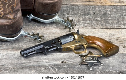 Old Western Pistol, Badge, Spurs And Cowboy Boots.