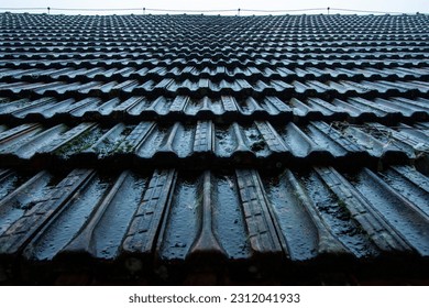 Old wet roof tiles during a heavy rain in perspective - Shutterstock ID 2312041933