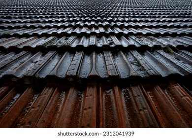 Old wet roof tiles during a heavy rain in perspective - Shutterstock ID 2312041939