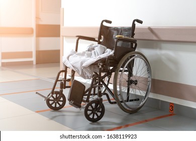 An Old Wheelchair In A Hospital Is Parked. No People. The Sun Shines