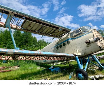 An old white and blue aircraft wreckage at a small airport in Laszki, Poland