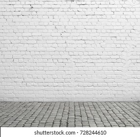 Old White Brick Wall And Cobblestone Floor.
