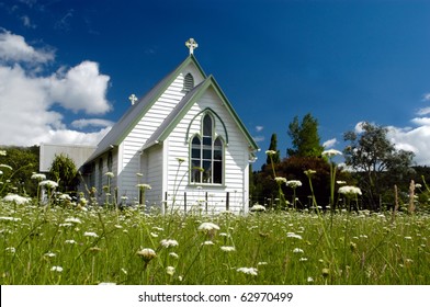 An old white church in a field full of spring white flowers in Kawakawa Northland New Zealand.No people. Copy space