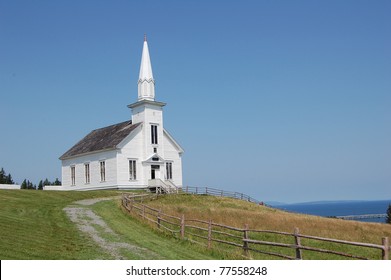 old white church in nova scotia, canada, overlooking the sea on summer's day