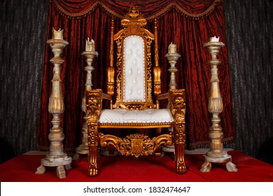 Old white and gold Royal chair with red curtains and candelabra in medieval vintage room. Throne for king in castle. Background in architecture or retro interior design. Copy space, text place - Shutterstock ID 1832474647