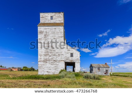 An old white grain elevator in a small town in the Canadian prairies.