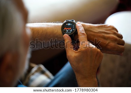 old white haired man using smart watch checking his cardiogram ecg 商業照片 © 