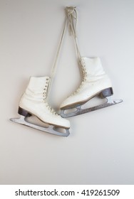 Old White Ice Skates Hanging On The Wall