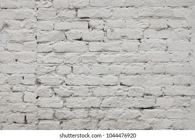 Old White Light Gray Texture Of A Brick Wall. Surface Of The Old White-brick Building. Wall With Cracked Structure Grunge Background. Solid Distressed Building Light Facade Textured Urban Background.