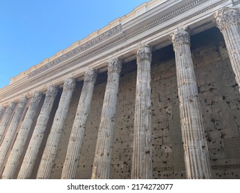 Old White Marble, Stone Pillars, Columns Of The Temple Of Hadrian (Il Tempio Di Adriano). It Is An Ancient Roman Structure Dedicated To The Emperor Hadrian. Popular Sightseeing Place.  Rome, Italy. 