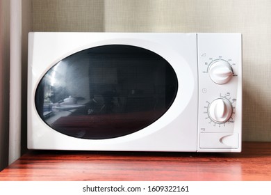 Old White Microwave Stands On The Kitchen Table