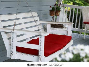 Old White Porch Swing With Red Cushions