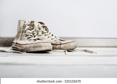 Old White Sneakers On Wooden Background