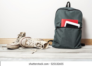 Old White Sneakers With School Bag On Wooden Background