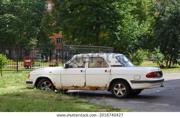 An old white Soviet car is\
parked in the courtyard, ulitsa Sedova, St. Petersburg, Russia,\
July 2021