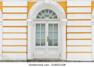 Old White Wooden Door In Yellow Wall, Background Texture. Classic Architecture Details