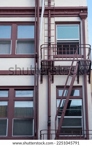Old WhiteBuilding with a Brown Metal Fire Escape.