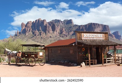 Old Wild West Cowboy Town With Horse Drawn Carriage And Mountains In Background