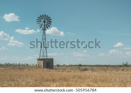 Old windmill at blue cloudy sky