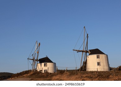 Old windmill, sunset, mountain, scenic view, historical windmill, twilight, rural landscape, windmill silhouette, evening sky, picturesque, golden hour, countryside, heritage site, traditional windmil - Powered by Shutterstock