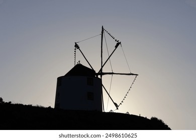 Old windmill, sunset, mountain, scenic view, historical windmill, twilight, rural landscape, windmill silhouette, evening sky, picturesque, golden hour, countryside, heritage site, traditional windmil - Powered by Shutterstock