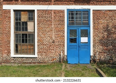 An Old Window With A Wooden Frame And A Blue Door. Facade Of Old Brick Building, Close Up.