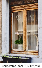 Old window with wooden frame and cute decorations in traditional medieval house