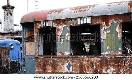 An old, windowless train car covered in rust, abandoned and weathered by time. The metal surface is corroded, with peeling paint and signs of decay, evoking a sense of history and forgotten journeys.
