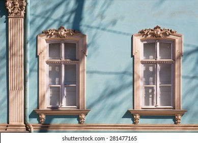 Old windows with carved architraves of historical building