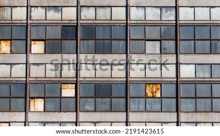 Old windows in a Soviet-era industrial building with a close-up view from the front. Windows of an abandoned industrial building. Windows of a building