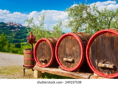 Old wine barrels and squeezer at the entrance of vine and oil stock. Sienna, Tuscany, Italy