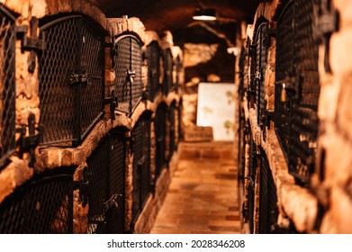 Old wine bottles dusting in an underground tratitional cellar. Small and old wine cellar with full wine bottles. Winery concept. Valtice Castle in South Moravia, Czech Republic, Europe