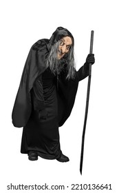 Old Witch In A Cloak Standing With A Stick Isolated Over White Background