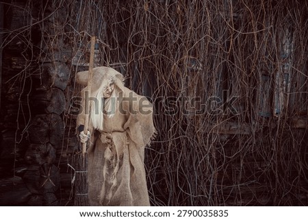 Old witch in a dark winter forest. Baba Yaga from a Russian fairy tale. Realistic scary makeup. Close-up. Old woman in tattered clothes.