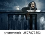 Old witch rising out behind balustrade with moonlight background. Scene is scary and creepy. Spooky Halloween concept