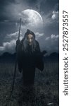 Old witch walking in a field with a stick. The sky is dark and cloudy, and there is a full moon in the background. Scene is scary and creepy. Spooky Halloween concept