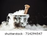 Old witcher cauldron illed with magic potion and deep smoke around at black background.