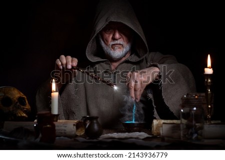 Old wizard conjures up elixir with magic wand