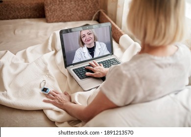 Old Woman In Bed Looking At Screen Of Laptop And Consulting With A Doctor Online At Home, Telehealth Services During Lockdown, Distant Video Call, Modern Tech Healthcare Application