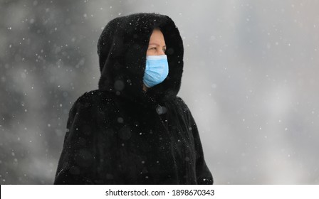 Old Woman In A Black Mink Coat Wearing A Medical Mask