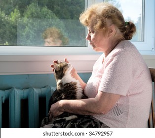 The old woman caress cat sitting at a window