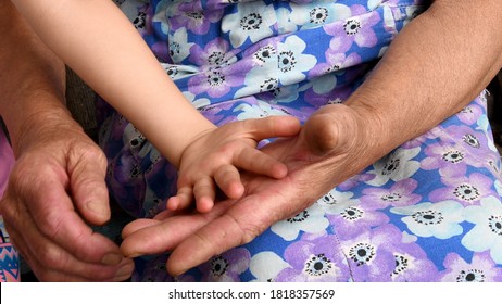 Old Woman And Child Hands Closeup. Grandmother Hold Little Hand Of Her Grandchild Small Girl. Diverse Hands Of 4 Year Old Child And 80 Year Old Woman