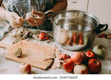 Old woman cuts apples for jam. Red ripe apples on table next to the jam pot. An elderly woman makes jam in her cottage on farm. Conservation and harvesting. Homemade delicious food. close-up - Powered by Shutterstock