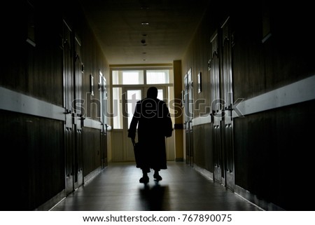 An old woman in the dark corridor