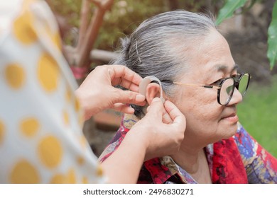 Old woman and daughter hands with hearing aid, help and support with healthcare at home. Person with disability concept. - Powered by Shutterstock