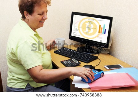 old woman earned on the crypto currency. Grandmother successfully bought bitcoins, does not need a pension. Grandma wants buys a car. old woman working at a computer. Earnings through the Internet