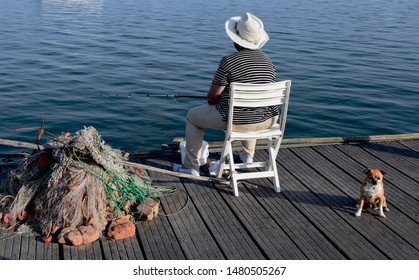 Old Woman Fishing In The Deck With A Dog	