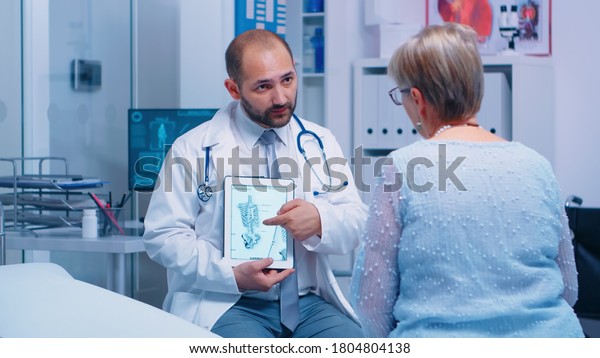 Old\
woman getting medical advice about osteoporosis bones disease from\
experienced doctor in private clinic sitting on hospital bed.\
Patient healthcare treatment and health\
consultation