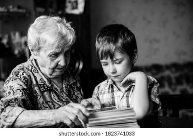 An Old Woman And Grandson. Black And White Photo.