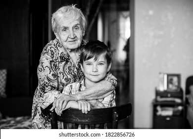 Old Woman And Grandson Posing For The Camera. Black And White Photo. 